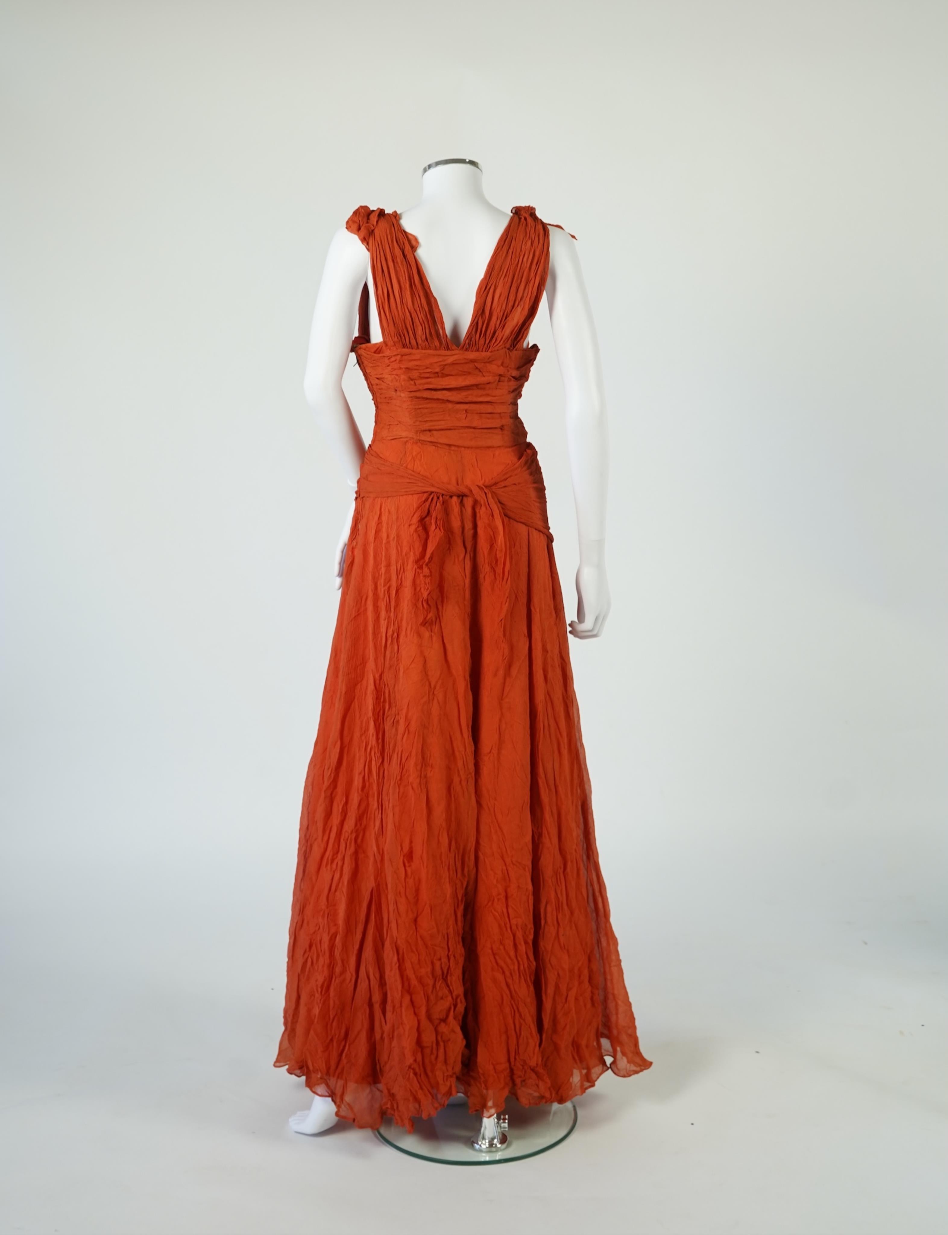 A 1940’s orange chiffon evening dress, with an orange silk taffeta lining, a pleated bodice and front apron panel tied at the back., 156 cm long. Condition - there are a few small holes in the chiffon at the back of the